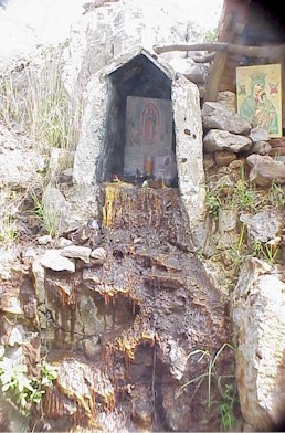 A roadside shrine shows evidence of 100s of candles burned in memory of a lost loved one